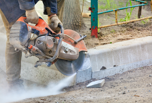 Concrete contractor using a curb saw to cut new concrete curbs