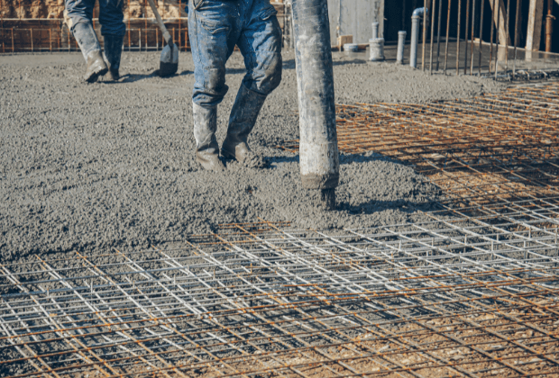 Pouring fresh concrete over rebar mesh in a new driveway